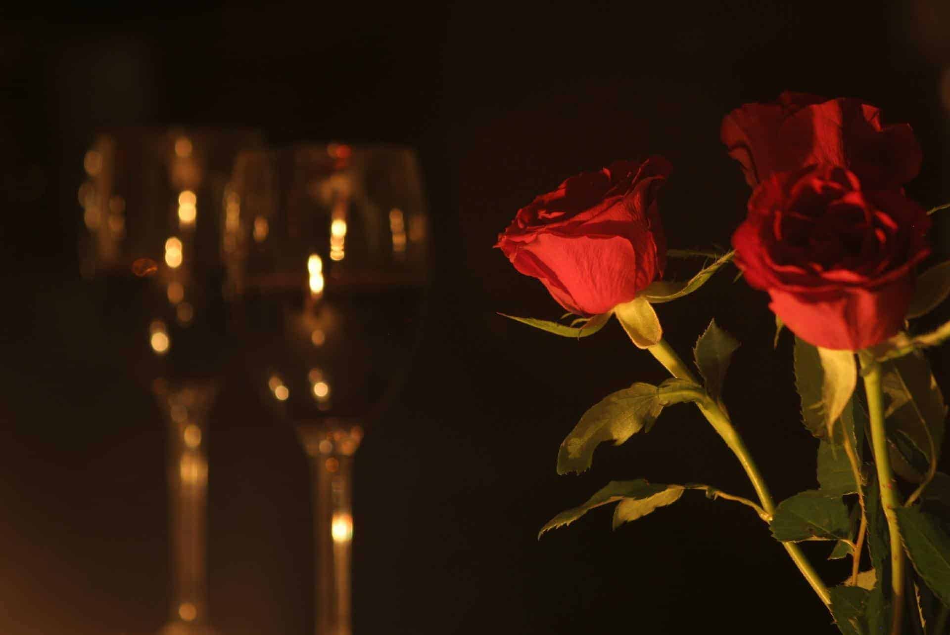 romantic setting with two wine glasses and a few red roses